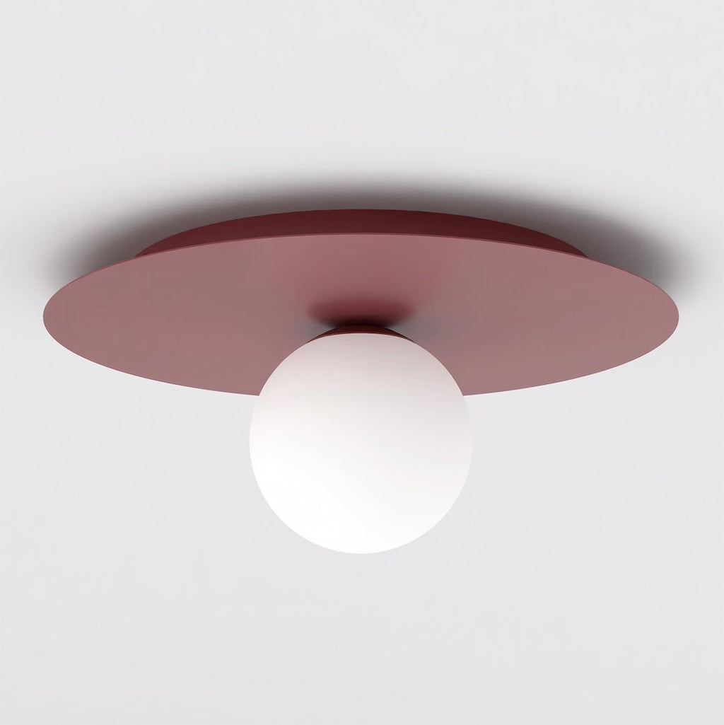 Ronde bordeauxrode plafondlamp met één witte glazen bol aan een wit plafond
