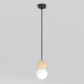 Zwarte hanglamp met houten bol en witte glazen kap aan een dun zwart snoer, tegen een lichtgrijze achtergrond