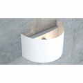 Witte halfronde wandlamp van gepoedercoat staal tegen een grijze betonlook muur, met zacht licht