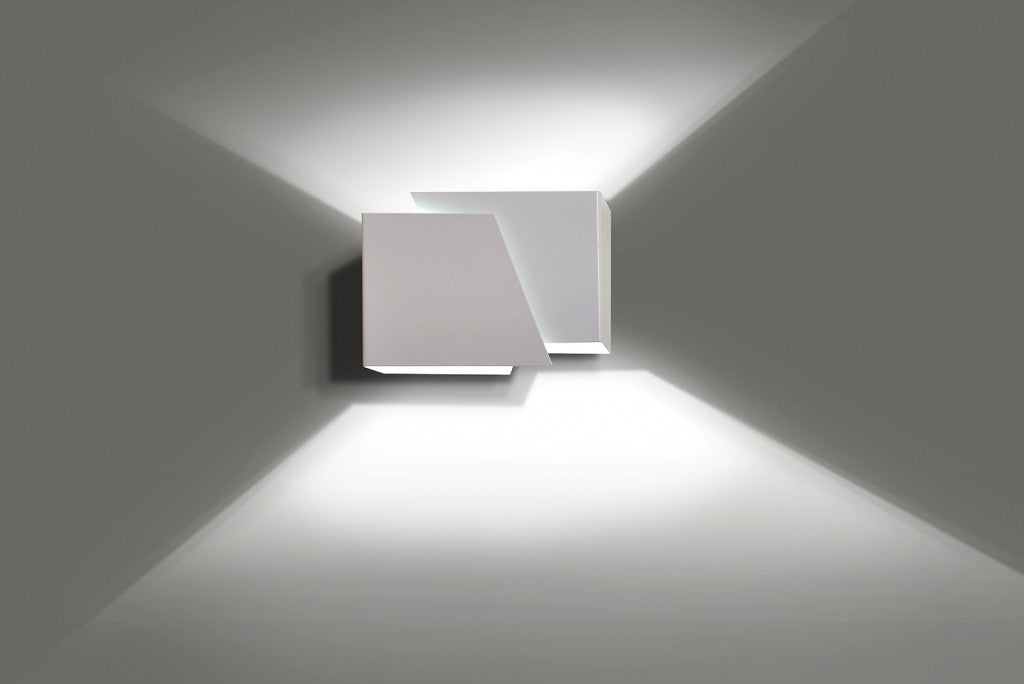Witte moderne wandlamp van twee verschoven vlakken die licht naar boven en beneden over de muur werpt