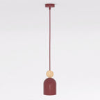 Bordeauxrode hanglamp met capsulevormige kap en rond houten accent aan een dun snoer