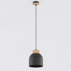 Zwarte koepelvormige hanglamp met houten rand en dun zwart snoer aan een plafondplaatje