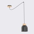 Zwarte hanglamp met matte stalen kap en houten ring, opgehangen aan een lang snoer met houten plafondplaat