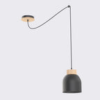 Zwarte hanglamp met matte stalen kap en houten ring, opgehangen aan een lang snoer met houten plafondplaat