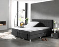 Wit splittopper hoeslaken op een antracietkleurige elektrische boxspring met opgeklapt hoofdeinde in een moderne slaapkamer