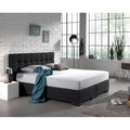 Wit hoeslaken op een boxspring met antracietkleurig hoofdbord in een slaapkamer met witte bakstenen muur