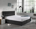 Wit molton hoeslaken om een matras op een antracietkleurig boxspringbed met gecapitonneerd hoofdbord