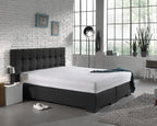 Wit molton hoeslaken om een matras op een antracietkleurig boxspringbed met gecapitonneerd hoofdbord