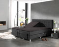 Verstelbaar boxspringbed met antracietkleurig splittopper hoeslaken en gestoffeerd hoofdbord in een moderne slaapkamer