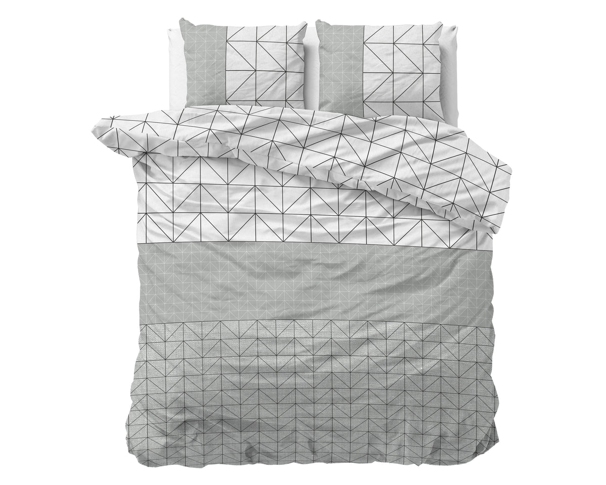 Dekbedovertrek met geometrische print in grijs en wit met zwarte lijnen, met twee bijpassende kussens op een bed