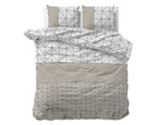 Opgemaakt bed met dekbedovertrek en twee kussens met geometrisch dessin in taupe, wit en zwarte lijnen