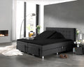 Zwart splittopper hoeslaken op een antraciet boxspring met knoopjes in het hoofdbord in een moderne slaapkamer