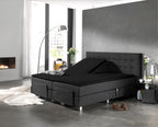 Zwart splittopper hoeslaken op een antraciet boxspring met knoopjes in het hoofdbord in een moderne slaapkamer