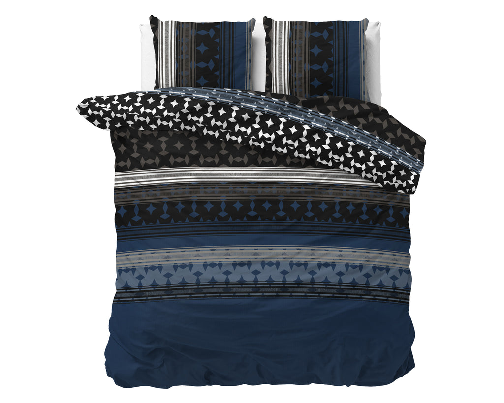 Marineblauw dekbedovertrek met grafische print van ruiten en strepen, omgeslagen hoek met zwart-wit patroon en twee kussens
