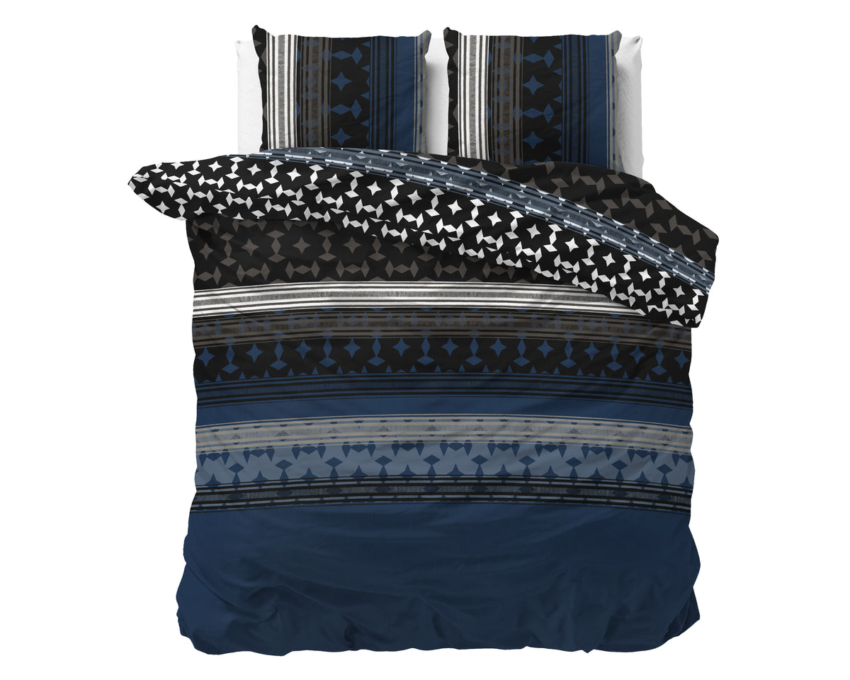 Marineblauw dekbedovertrek met grafische print van ruiten en strepen, omgeslagen hoek met zwart-wit patroon en twee kussens