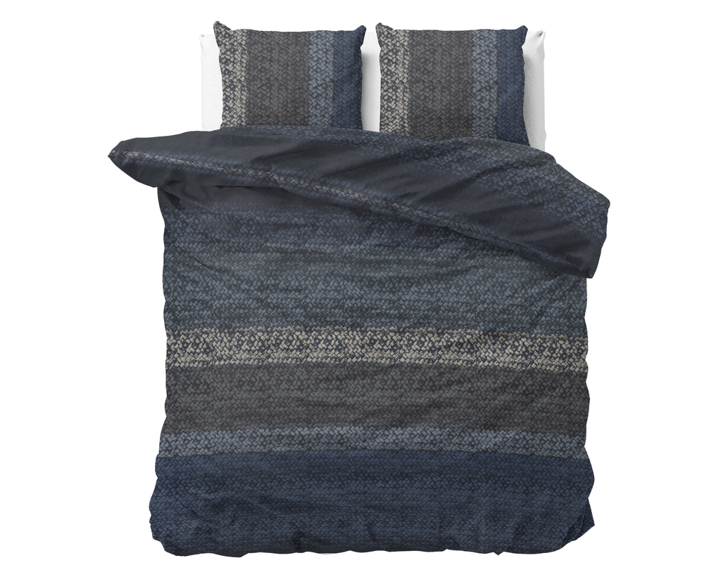 Blauw flanellen dekbedovertrek met gebreid kleurverloop en twee bijpassende kussenslopen op een bed