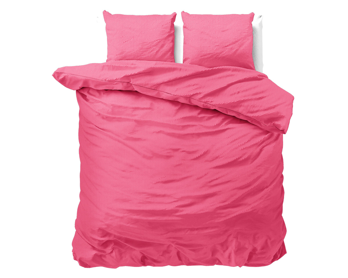 Roze dekbedovertrek met twee bijpassende kussens op een bed, de dekbedhoek is teruggeslagen