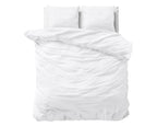 Wit stonewashed dekbedovertrek op een bed met witte kussens, gezien van bovenaf