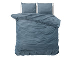 Blauw stonewashed dekbedovertrek met twee bijpassende kussens op een bed, bovenaanzicht