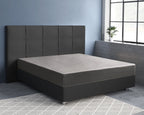 Grijs satijnen hoeslaken op een matras met donker hoofdbord en boxspring in een slaapkamer met blauwe muur