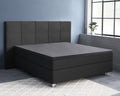 Antracietkleurig boxspringbed met gestoffeerd hoofdbord en donker topperlaken op het matras in een slaapkamer