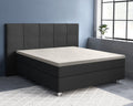 Crèmekleurig topper hoeslaken op een donkergrijs boxspringbed met gestoffeerd hoofdbord in een slaapkamer met blauwe muur