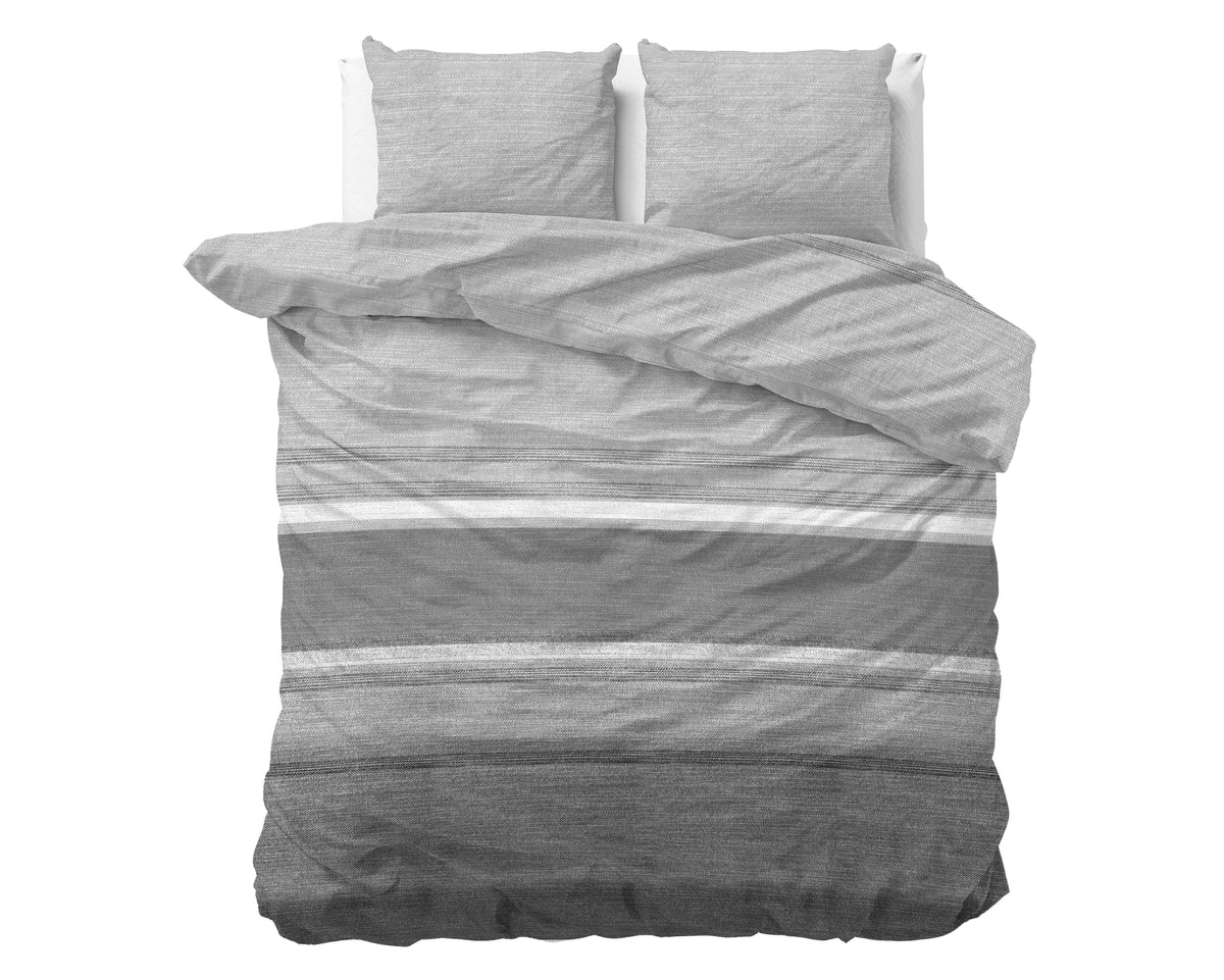 Opgemaakt bed met grijs gestreept flanellen dekbedovertrek en twee bijpassende kussens