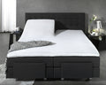 Wit waterdicht split hoeslaken op een verstelbaar donkergrijs boxspringbed met gestoffeerd hoofdbord