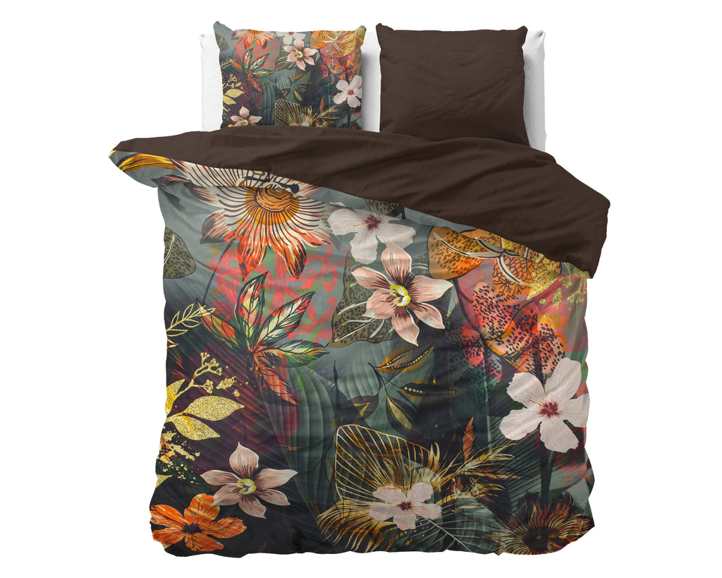 Dekbedovertrek met bloemenprint in groen, oranje en roze en effen bruine keerzijde, met twee kussens op een bed