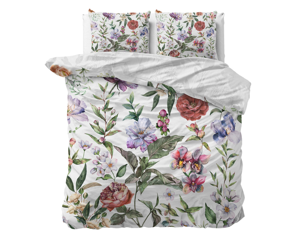 Wit dekbedovertrek met kleurrijke bloemenprint en twee bijpassende kussens, deels omgeslagen