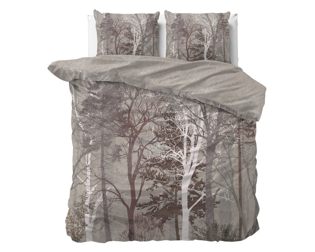 Taupe dekbedovertrek met bosprint van boomsilhouetten en twee bijpassende kussenslopen op een bed