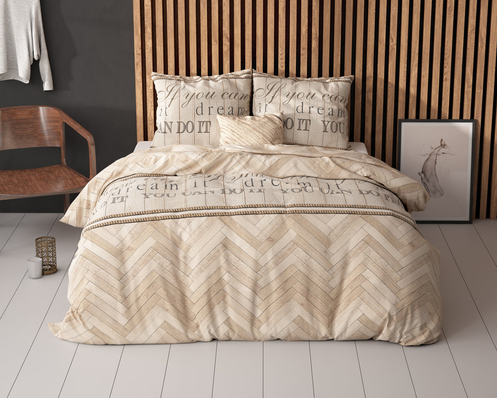Bed met zandkleurig dekbedovertrek met visgraatpatroon en tekstprint, voor een houten lamellenwand