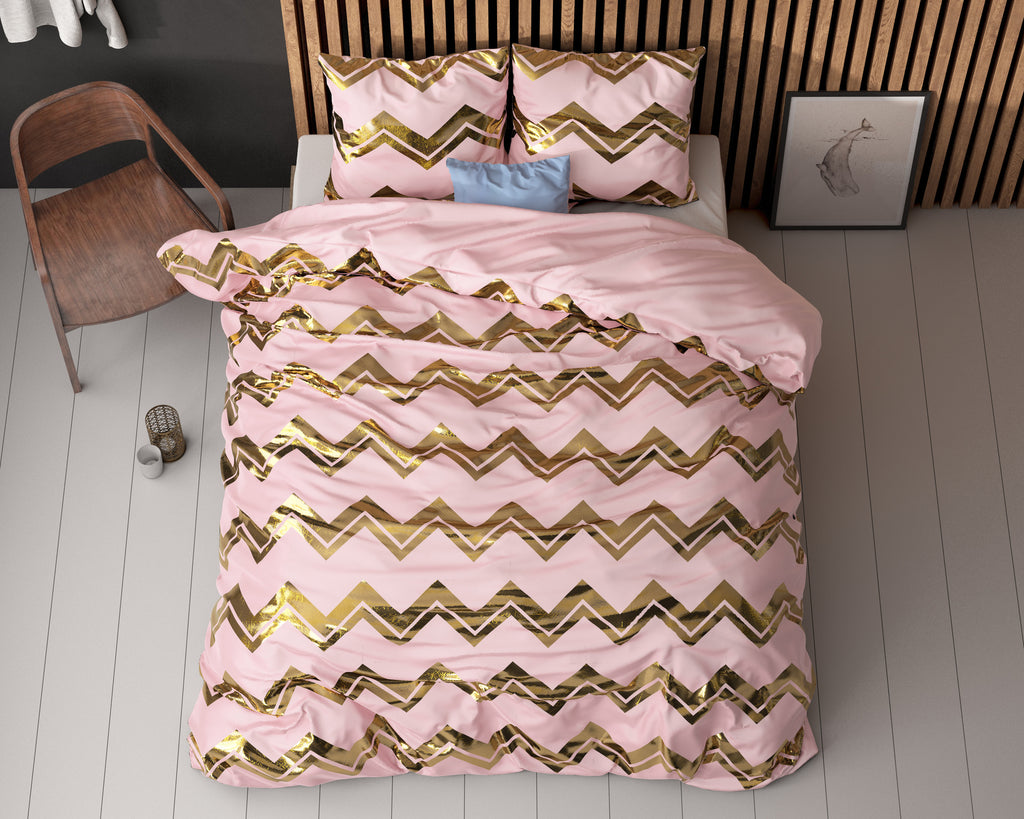 Roze dekbedovertrek met goudkleurige zigzagprint en bijpassende kussenslopen op een bed voor een houten latwand