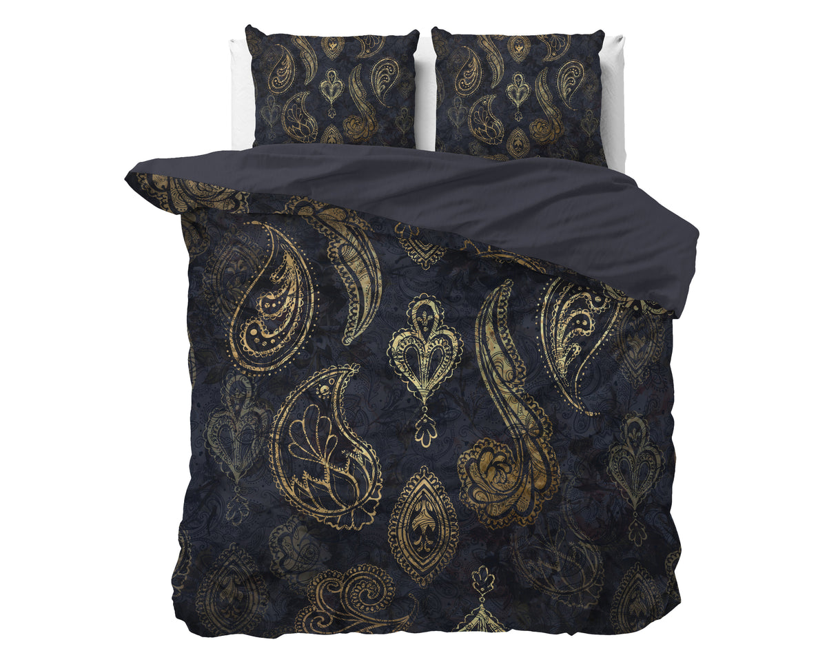 Donkerblauw dekbedovertrek met goudkleurig paisleydessin en bijpassende kussenslopen op een bed, achterzijde effen