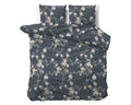 Opgemaakt bed met indigo dekbedovertrek en twee kussens met roze en witte bloemenprint