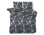 Opgemaakt bed met indigo dekbedovertrek en twee kussens met roze en witte bloemenprint
