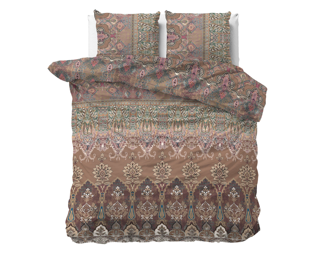 Bruin dekbedovertrek met sierlijk bohemian motief in roze, groen en beige, met twee bijpassende kussenslopen op een bed