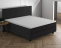 Wit topper op een antracietkleurig boxspringbed met bijpassend hoofdbord in een lichte slaapkamer met visgraatvloer