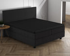 Zwart topper hoeslaken op een zwarte boxspring met hoofdbord in een slaapkamer met visgraatvloer