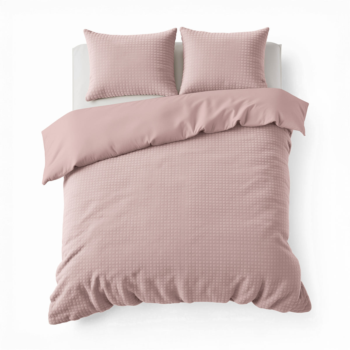 Roze teddy dekbedovertrek met geruite structuur en twee bijpassende kussenslopen op een bed, bovenaanzicht