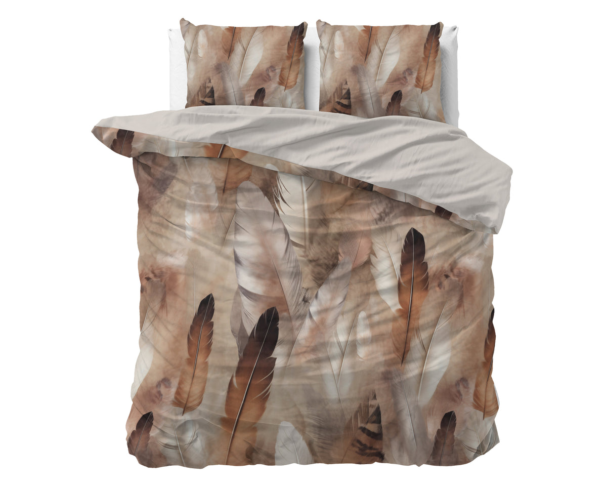Dekbedovertrek met veren print in bruin en beige, uni taupe binnenkant en twee bijpassende kussens op een bed