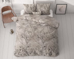 Dekbedovertrek met zwarte bloemenprint op taupe ondergrond op een bed met kussens, naast een houten stoel