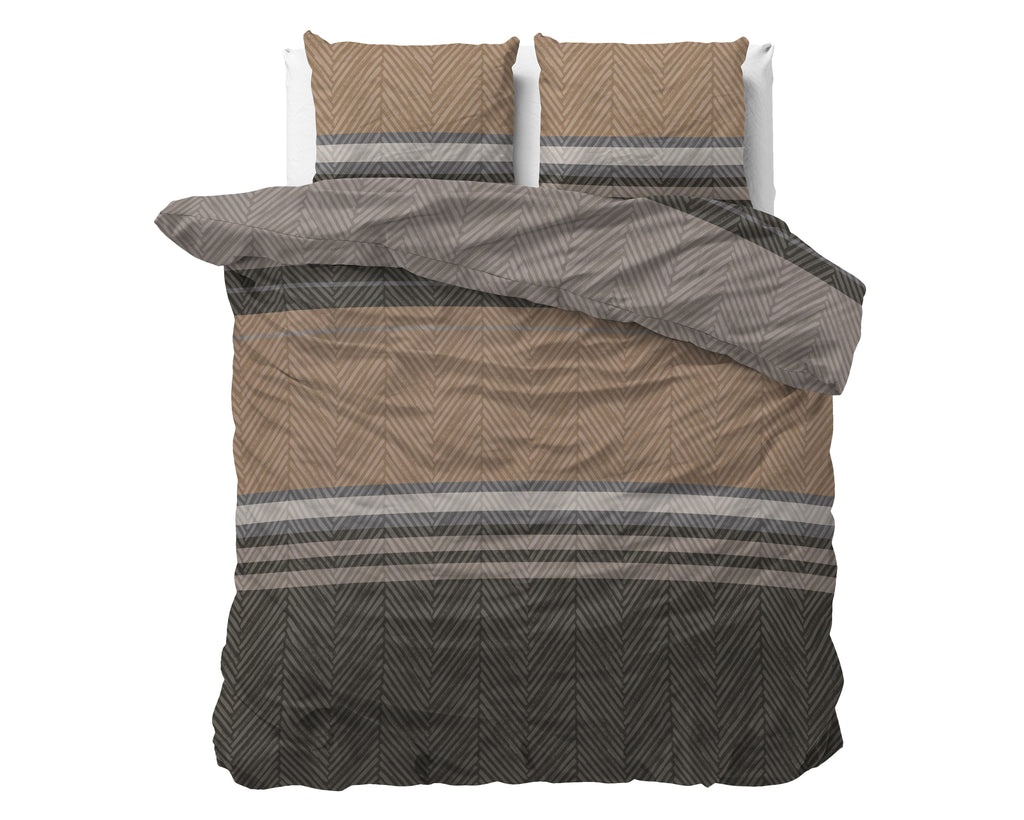 Dekbedovertrek met visgraatmotief en strepen in bruin, taupe en antraciet op een bed met twee kussens