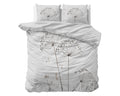 Wit dekbedovertrek met bloemenprint in taupe en bruin, met twee kussens op een bed