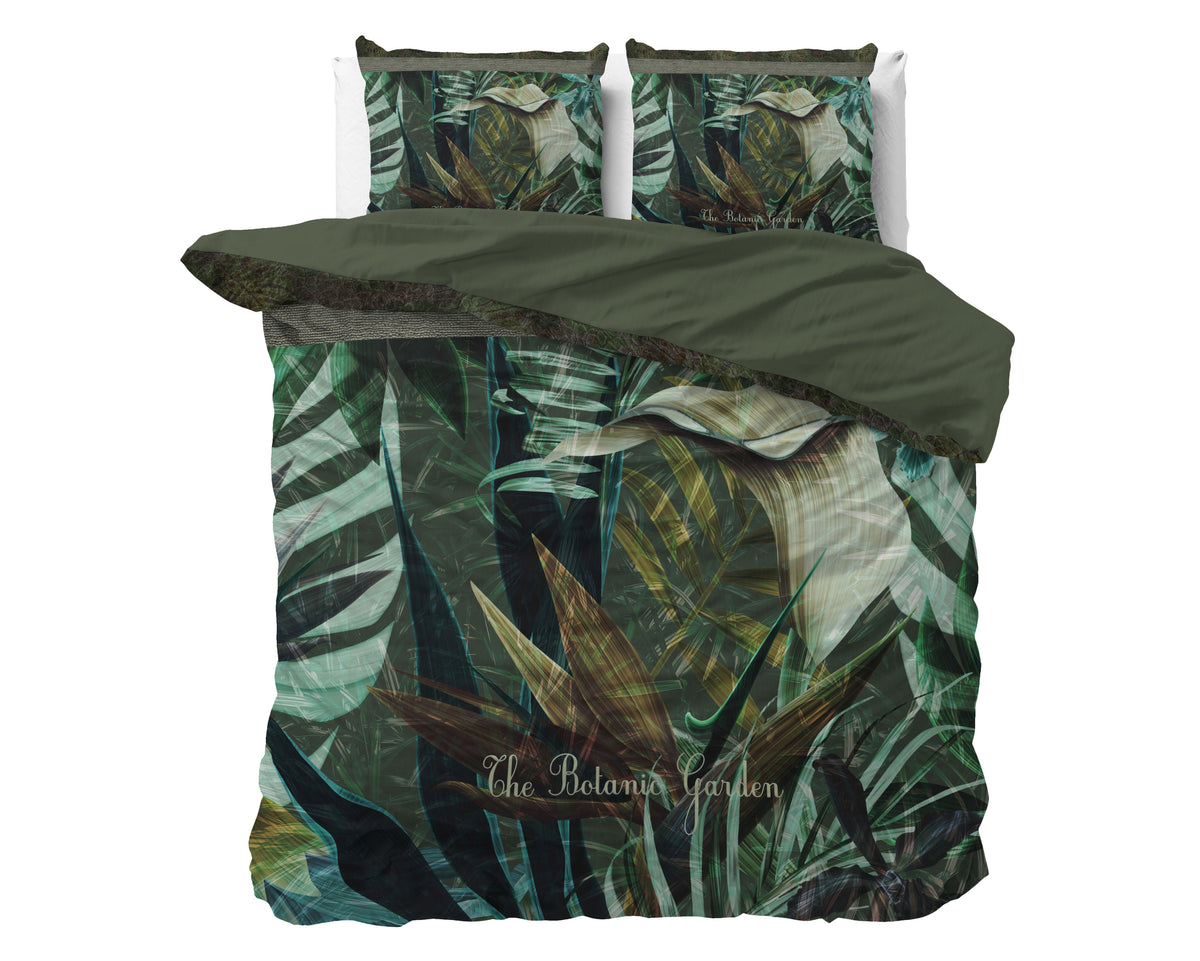 Groen dekbedovertrek met botanische bladprint en kussenslopen met dezelfde print op een bed