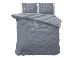 Blauwgrijs dekbedovertrek met lichte tekst Always Kiss me goodnight en twee kussenslopen met dezelfde print op een bed