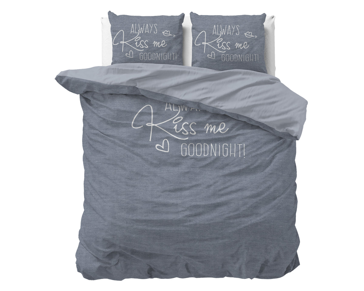 Blauwgrijs dekbedovertrek met lichte tekst Always Kiss me goodnight en twee kussenslopen met dezelfde print op een bed