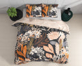 Zwart dekbedovertrek met oranje, perzik en crème bloemenprint en twee bijpassende kussenslopen op een bed, bovenaanzicht