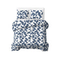 Opgemaakt bed met blauw-wit grafisch lazy dekbed en twee bijpassende kussens, gezien van boven