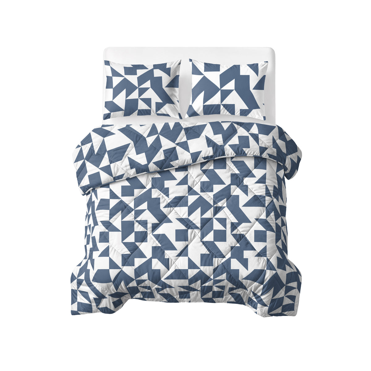 Opgemaakt bed met blauw-wit grafisch lazy dekbed en twee bijpassende kussens, gezien van boven